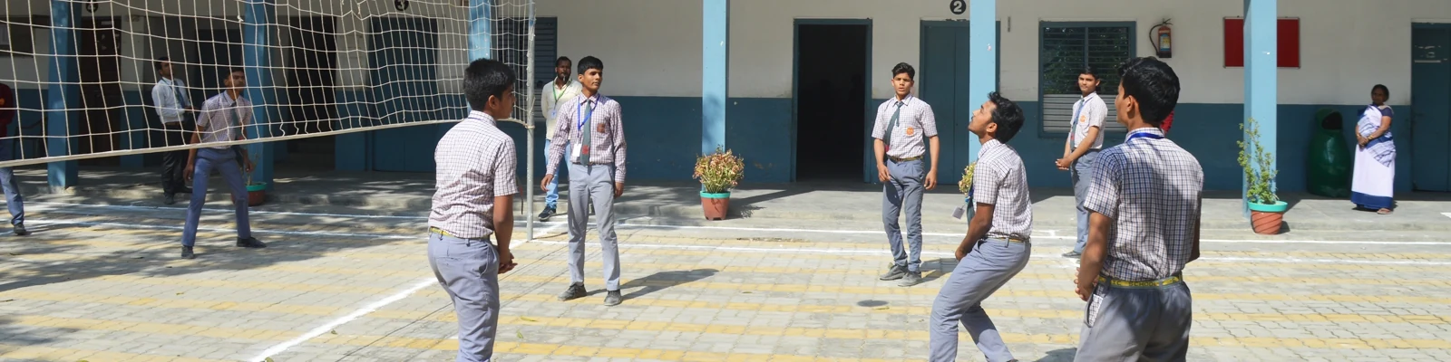 Students playing volleyball in the school courtyard